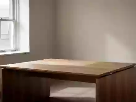 Ein minimalistischer, leerer Schreibtisch aus Holz in einem hellen Raum mit natürlichem Lichteinfall. - Foto: über boerse-global.de
