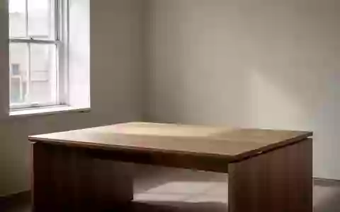 Ein minimalistischer, leerer Schreibtisch aus Holz in einem hellen Raum mit natürlichem Lichteinfall. - Foto: über boerse-global.de