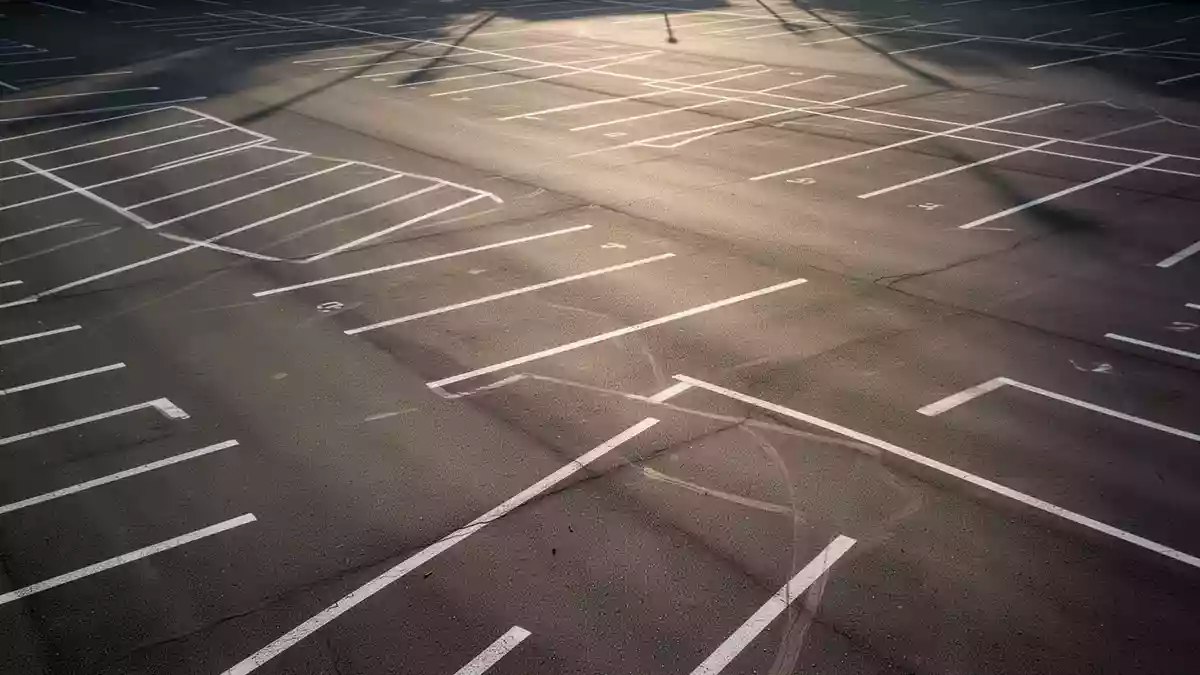 Leerer Parkplatz mit markierten Stellflächen und Fahrgassen aus der Vogelperspektive bei Tageslicht Illustration mit AI erstellt.