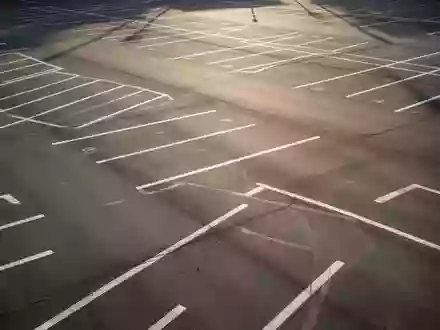 Leerer Parkplatz mit markierten Stellflächen und Fahrgassen aus der Vogelperspektive bei Tageslicht - Foto: über boerse-global.de