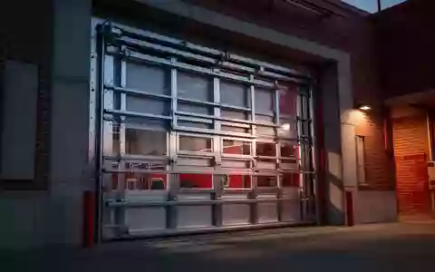 Robuste Stahltore eines Feuerwehrhauses in der Dämmerung als Symbol für baulichen Einbruchschutz. - Foto: über boerse-global.de