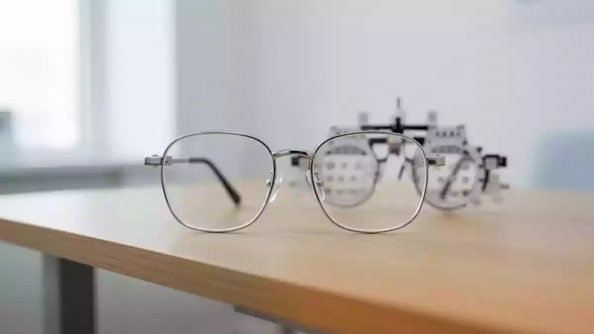 Ein minimalistischer Untersuchungsraum beim Augenoptiker mit einer unscharfen Messbrille auf einem Holztisch. Illustration mit AI erstellt.