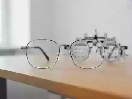 Ein minimalistischer Untersuchungsraum beim Augenoptiker mit einer unscharfen Messbrille auf einem Holztisch. - Foto: über boerse-global.de
