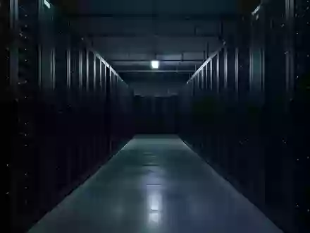 Ein dunkler, minimalistischer Serverraum mit unbeleuchteten Server-Racks und blauem Umgebungslicht. - Foto: über boerse-global.de