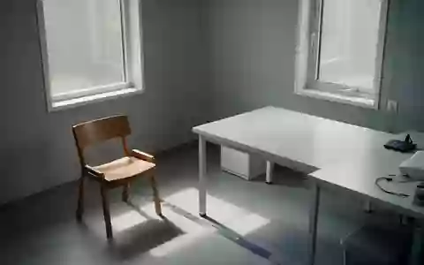 Ein leeres, minimalistisches Behandlungszimmer mit einem hölzernen Stuhl und einem Tisch in ruhigem Tageslicht. - Foto: über boerse-global.de