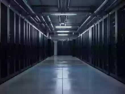 Ein modern ausgestatteter, menschenleerer Serverraum in kühlem, blauem Licht mit Fokus auf die industrielle Architektur. - Foto: über boerse-global.de