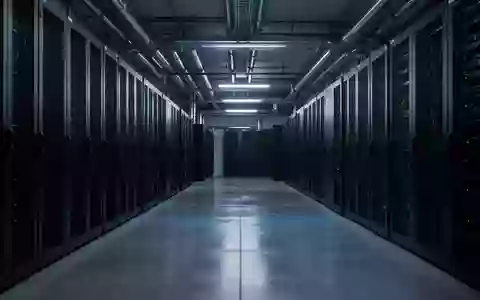Ein modern ausgestatteter, menschenleerer Serverraum in kühlem, blauem Licht mit Fokus auf die industrielle Architektur. - Foto: über boerse-global.de