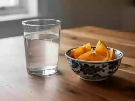 Ein Glas Wasser und eine Schale mit Zitrusfrüchten auf einem Holztisch bei natürlichem Tageslicht. - Foto: über boerse-global.de