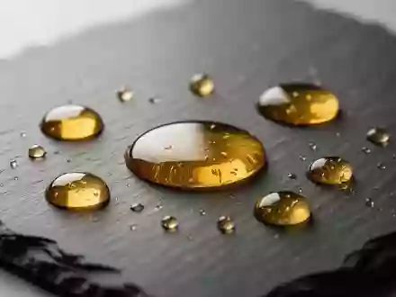 Goldene Öltröpfchen auf einer dunklen Schieferoberfläche, die an die Untersuchung von Nahrungsergänzungsmitteln erinnern. - Foto: über boerse-global.de