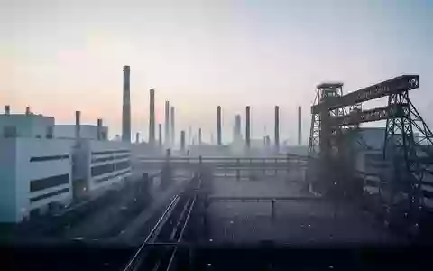 Weitläufige, moderne Industrieanlage in der Morgendämmerung mit großen Fabrikgebäuden und Stahlinfrastruktur. - Foto: über boerse-global.de