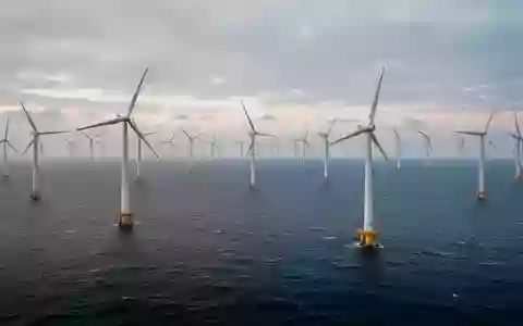 Ein weitläufiger Offshore-Windpark mit zahlreichen Windkraftanlagen auf dem offenen Meer bei Tagesanbruch. - Foto: über boerse-global.de