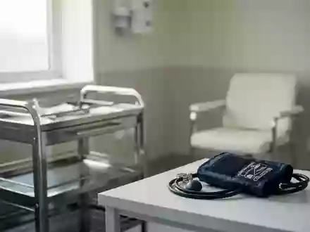 Ein klinischer Untersuchungsraum mit einem medizinischen Wagen und einem Blutdruckmessgerät in einer sterilen Umgebung. - Foto: über boerse-global.de