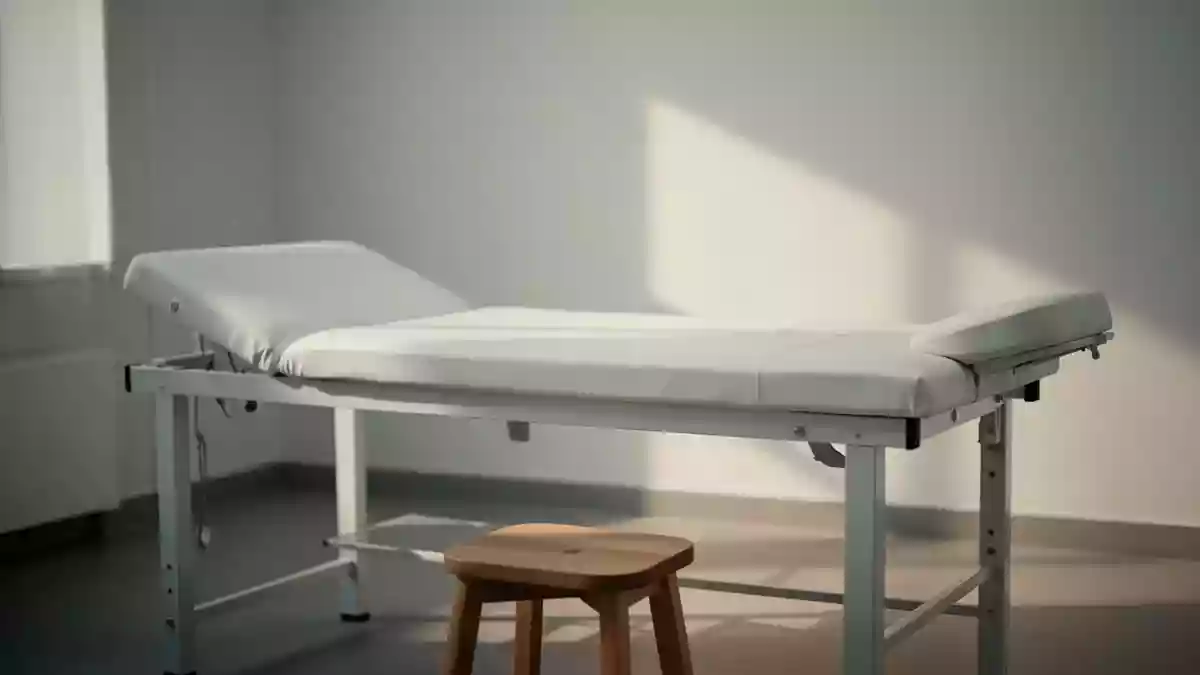 Ein minimalistischer, leerer Behandlungsraum in einem medizinischen Zentrum mit sanftem Tageslicht. Illustration mit AI erstellt.