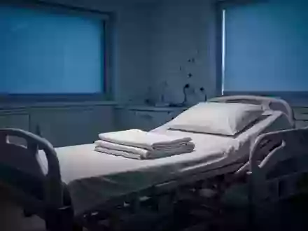 Ein leeres, ordentlich gemachtes Krankenhausbett in einem abgedunkelten Schlaflabor bei sanftem, blauem Licht. - Foto: über boerse-global.de