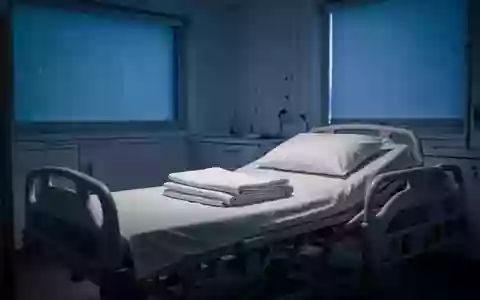 Ein leeres, ordentlich gemachtes Krankenhausbett in einem abgedunkelten Schlaflabor bei sanftem, blauem Licht. - Foto: über boerse-global.de