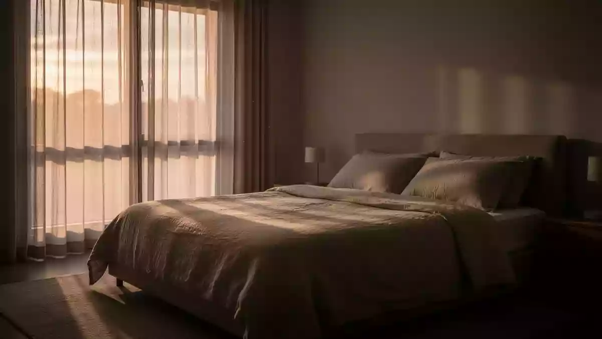 Ein ruhig gestaltetes Schlafzimmer in den frühen Morgenstunden mit sanftem Tageslicht und neutraler Bettwäsche. Illustration mit AI erstellt.