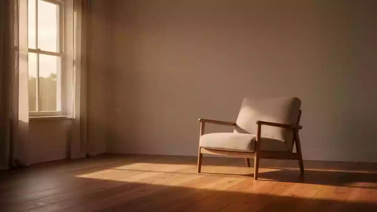 Ein minimalistisch eingerichteter, sonnendurchfluteter Wohnraum mit einem leeren Sessel vor einem Fenster. Illustration mit AI erstellt.