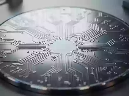 Nahaufnahme eines modernen Silizium-Wafers mit komplexen, metallischen Leiterbahnstrukturen in einer Laborumgebung. - Foto: über boerse-global.de
