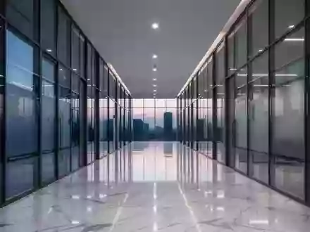 Ein leerer, moderner Büroflur aus Glas und Stahl in der Abenddämmerung mit polierten Böden und minimalistischer Architektur. - Foto: über boerse-global.de