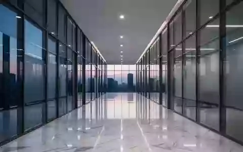 Ein leerer, moderner Büroflur aus Glas und Stahl in der Abenddämmerung mit polierten Böden und minimalistischer Architektur. - Foto: über boerse-global.de