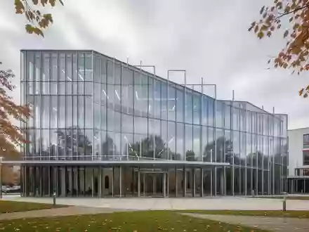Moderne Glasfassade eines Verwaltungsgebäudes im Saarland an einem bewölkten Tag. - Foto: über boerse-global.de