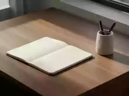 Ein aufgeräumter, minimalistischer Schreibtisch aus Holz mit einem leeren Notizbuch und einem Stiftehalter bei natürlichem Licht. - Foto: über boerse-global.de