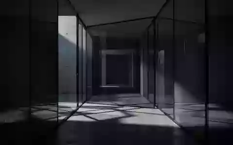 Ein minimalistischer, dunkel beleuchteter Flur mit geometrischen Schatten auf einem Betonboden. - Foto: über boerse-global.de