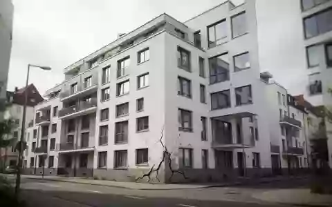 Moderne Wohnanlage mit sichtbaren Rissen in der Fassade an einem bewölkten Tag. - Foto: über boerse-global.de