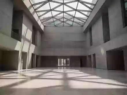 Ein minimalistisches, modernes Regierungsgebäude mit hohen Betonwänden und geometrischen Glasdecken bei natürlichem Tageslicht. - Foto: über boerse-global.de