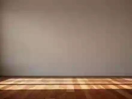 Ein heller, minimalistisch gestalteter Wohnraum mit einer schlichten Wand und Holzboden im sanften Morgenlicht. - Foto: über boerse-global.de