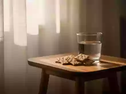 Ein Glas Wasser und Vollkornkekse auf einem Holztisch in einem hellen, sonnendurchfluteten Raum. - Foto: über boerse-global.de