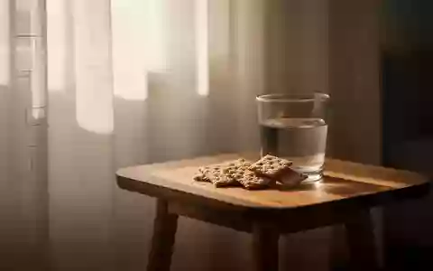 Ein Glas Wasser und Vollkornkekse auf einem Holztisch in einem hellen, sonnendurchfluteten Raum. - Foto: über boerse-global.de