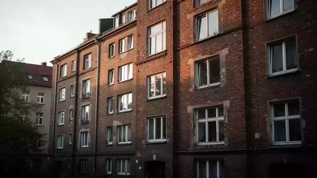 Fassade eines mehrstöckigen Wohnhauses in einem städtischen Wohnviertel bei spätem Nachmittagslicht. Illustration mit AI erstellt.