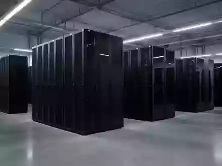 Reihen von schwarzen Server-Schränken in einem modernen, minimalistischen Rechenzentrum mit poliertem Betonboden. - Foto: über boerse-global.de