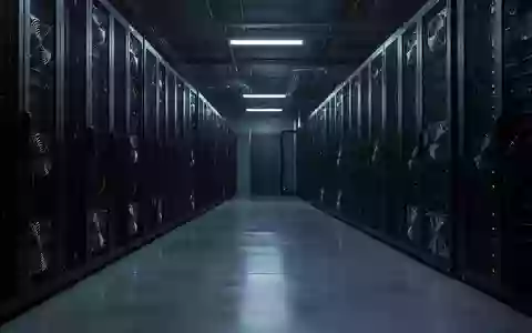 Dunkler, moderner Serverraum mit stummen Serverracks in einer kühlen, technologischen Umgebung. - Foto: über boerse-global.de
