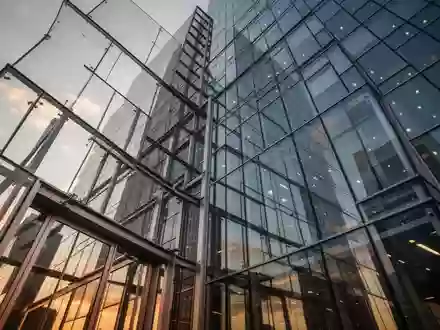 Nahaufnahme der modernen Glasfassade eines Hochhauses bei Tageslicht. - Foto: ĂŒber boerse-global.de