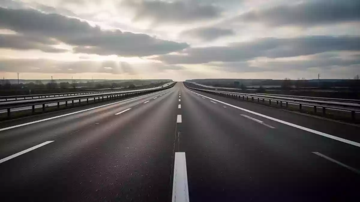 Leere Asphaltstraße auf einer Autobahn bei bewölktem Himmel ohne Fahrzeuge oder Schilder. Illustration mit AI erstellt.