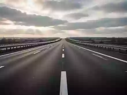 Leere Asphaltstraße auf einer Autobahn bei bewölktem Himmel ohne Fahrzeuge oder Schilder. - Foto: über boerse-global.de