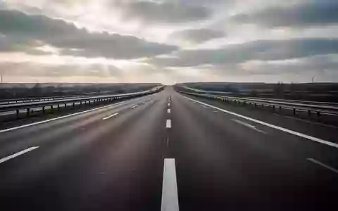 Leere Asphaltstraße auf einer Autobahn bei bewölktem Himmel ohne Fahrzeuge oder Schilder. - Foto: über boerse-global.de