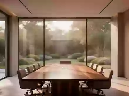 Ein minimalistischer, leerer Konferenzraum mit natürlichem Licht und Blick auf einen Garten. - Foto: über boerse-global.de