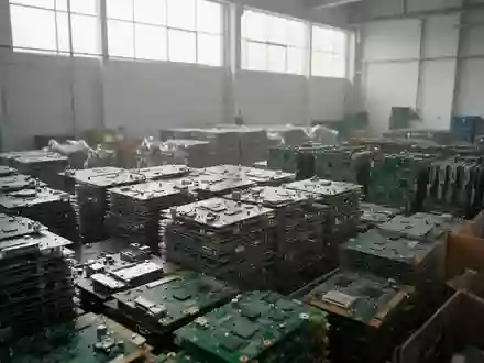 Nahaufnahme von recycelten Platinen und elektronischen Bauteilen in einer sortierten Lagerumgebung. - Foto: über boerse-global.de