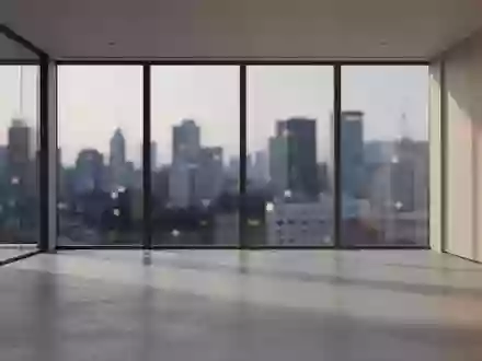 Ein minimalistisches, modernes Büro mit großen Glasfronten und Blick auf eine verschwommene Stadt bei Dämmerung. - Foto: über boerse-global.de