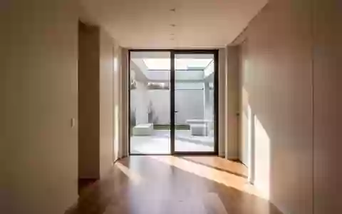 Ein heller, moderner Flur in einem Wohnhaus mit bodentiefen Fenstern und viel Tageslicht. - Foto: über boerse-global.de