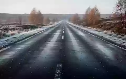 Eine mit Reif bedeckte, glatte Asphaltstraße an einem kalten Herbstmorgen. - Foto: über boerse-global.de