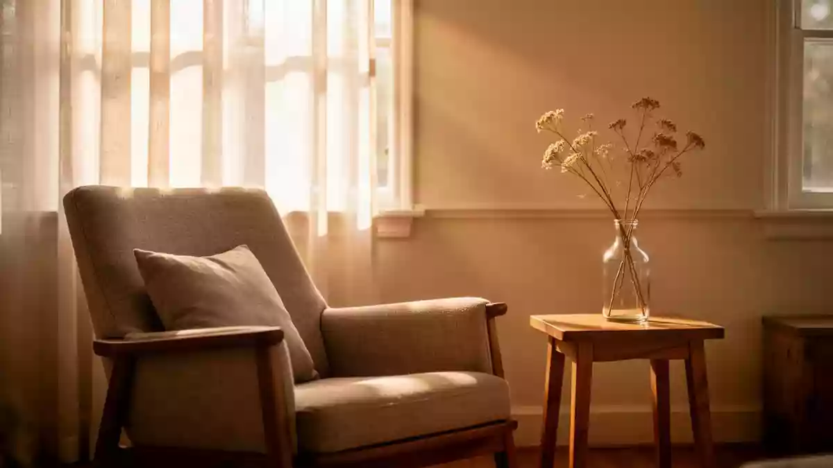 Ein ruhiger, sonnendurchfluteter Raum mit einem gemütlichen Sessel und einer Blumenvase am Fenster. Illustration mit AI erstellt.