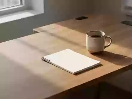 Ein minimalistischer, leerer Schreibtisch in sanftem Morgenlicht mit einer Kaffeetasse und einem Notizbuch. - Foto: über boerse-global.de