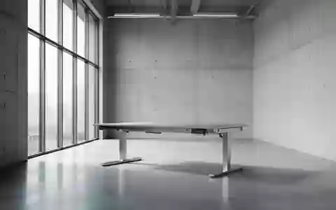 Ein minimalistischer, moderner Arbeitsbereich in einem industriellen Studio mit hohen Decken und natürlichem Lichteinfall. - Foto: über boerse-global.de