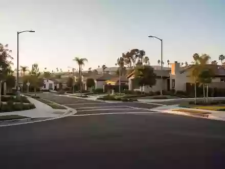 Eine ruhige Wohnstraße in San Diego bei Sonnenuntergang mit asphaltierten Wegen und grüner Bepflanzung. - Foto: über boerse-global.de