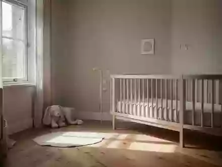 Minimalistisch eingerichtetes Kinderzimmer mit sanftem Tageslichteinfall auf einem Holzboden. - Foto: ĂĽber boerse-global.de