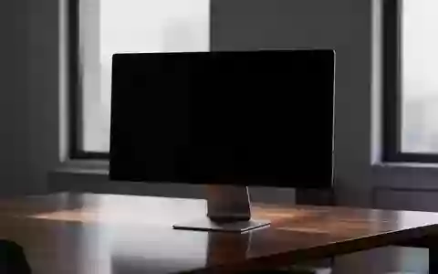 Ein minimalistischer, dunkel gehaltener Arbeitsplatz mit einem ausgeschalteten Monitor in einer ruhigen Büroumgebung. - Foto: über boerse-global.de